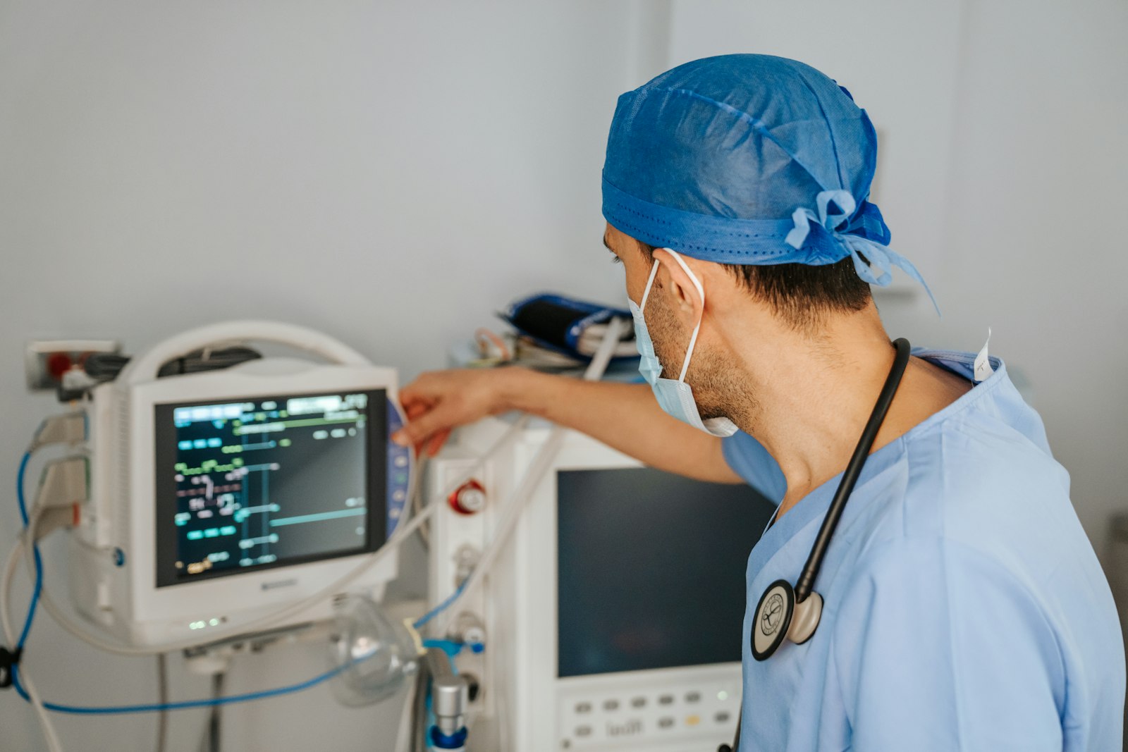 Clinician reviewing information on a monitor Clinician in scrubs with a stethoscope reviewing digital information on a monitor